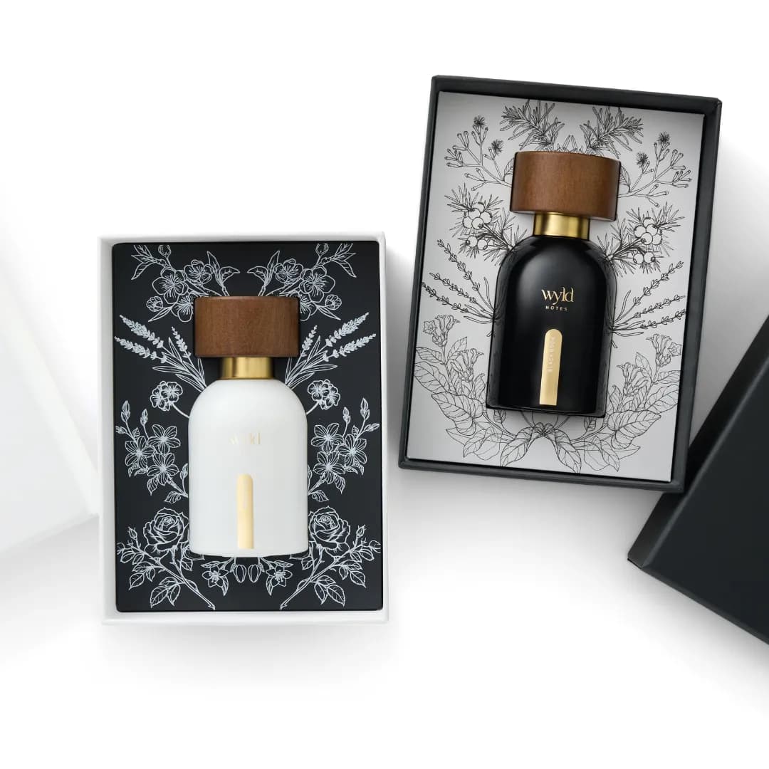 White Lie und Black Book in ihren Geschenkschachteln mit botanischen Zeichnungen